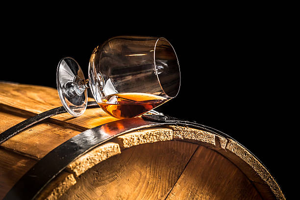 Glass of cognac on the old wooden barrel.
